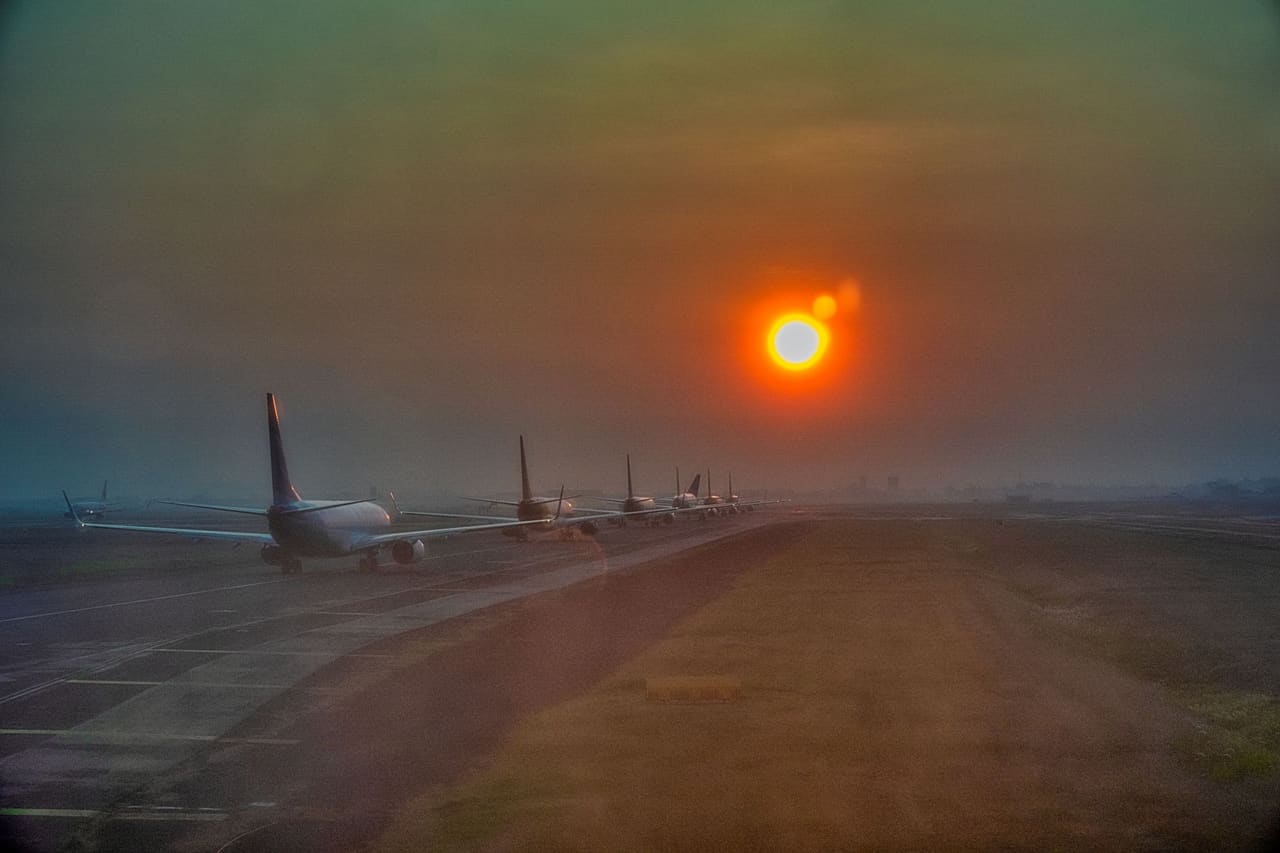 Airliners queued on the tarmac at sunset