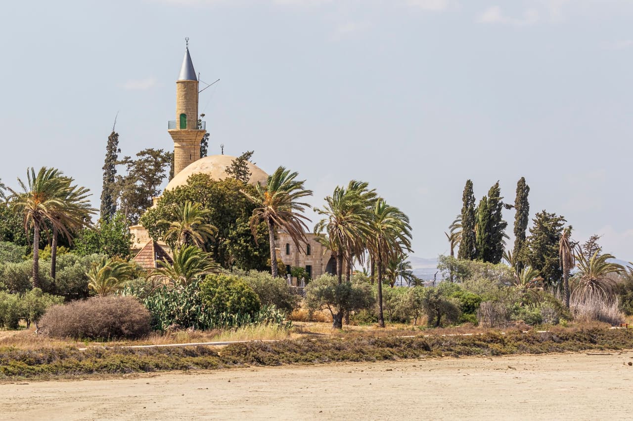 Hala Sultan Tekke and palm trees beyond the dry salt-lake bed