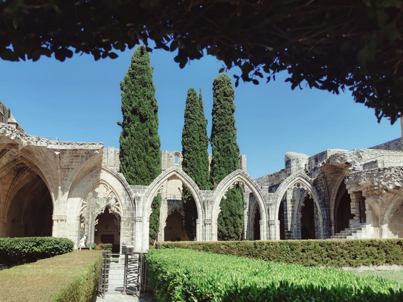 Bellapais Manastırı'nın gotik kemerli avlusu ve serviler